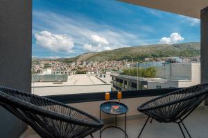 a balcony with two chairs and a view of a city at City Residences in Dubrovnik