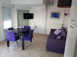 ein Wohnzimmer mit einem Tisch und einem lila Sofa in der Unterkunft Apartman Mare in Pješčana Uvala