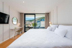 ein Schlafzimmer mit einem großen weißen Bett und einem Fenster in der Unterkunft City Residences in Dubrovnik