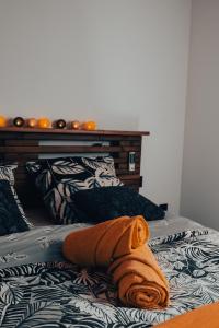 - un lit avec une serviette orange dans l'établissement Villa Loïsao, à Saint-Pierre