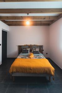 - une chambre avec un grand lit et une couverture jaune dans l'établissement Villa Loïsao, à Saint-Pierre