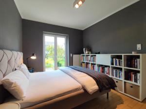 a bedroom with a bed and a book shelf with books at Zen Apartment - spacious - garden - kitchen in Karlsruhe