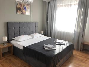 a bedroom with a large bed with two towels on it at Pensiunea Armonia in Nădăşelu