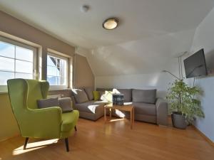 ein Wohnzimmer mit einem Sofa und einem Stuhl in der Unterkunft Sommereck Appartements in Seeboden