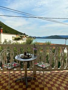 una mesa y sillas en un patio con vistas al agua en Matijaš Rooms - 20m from the beach, en Klek