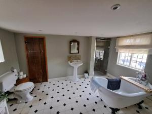 a bathroom with a tub and a toilet and a sink at Wilde Rooms in Weston