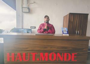 a man standing at a counter with his hands up at Haut Monde King's Paradise Resort in Kanatal