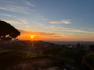 a sunset over a city with the sun in the sky at Residence La Villa in Montescudaio