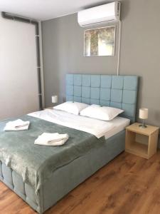 a bedroom with a large bed with two towels on it at Pensiunea Armonia in Nădăşelu