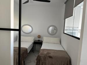 sypialnia z dwoma łóżkami i lustrem w obiekcie Bonito apartamento w Marbelli