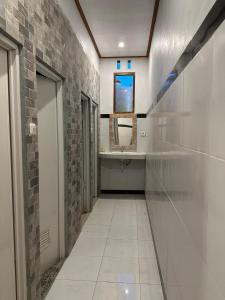 - un couloir d'une salle de bains pourvue d'un lavabo et d'un miroir dans l'établissement Penida Hills Hostel, à Nusa Penida