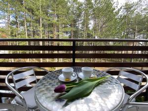 een tafel met twee koffiekopjes en tulpen erop bij Miris tisine in Zlatibor