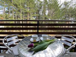 a table with two coffee cups and tulips on it at Miris tisine in Zlatibor