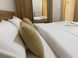 een slaapkamer met een bed met witte lakens en kussens bij Miris tisine in Zlatibor
