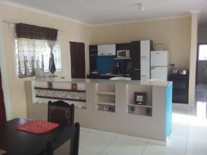 a kitchen with a white counter and a refrigerator at Protea Avenue Margate in Margate