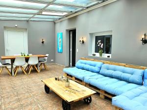 una sala de estar con sofás azules y una mesa. en Selker Noor Apartments, en Schleswig