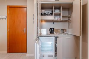 uma pequena cozinha com um frigorífico e uma porta em Regina Apartment em Turim