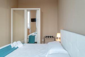 um quarto com uma cama branca e um espelho em Regina Apartment em Turim
