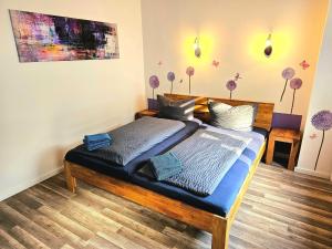 Schlafzimmer mit einem Bett mit blauer Bettwäsche in der Unterkunft Ferienwohnung am Selker Noor in Schleswig