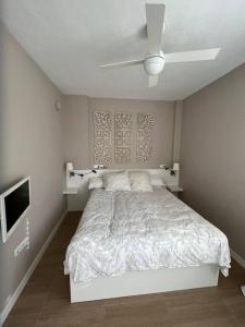 Habitación blanca con cama y TV en Costa Ballena - Duplex Playa Lar Beach House, en Costa Ballena