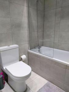 y baño con aseo blanco y bañera. en Home Away Barking, en Barking