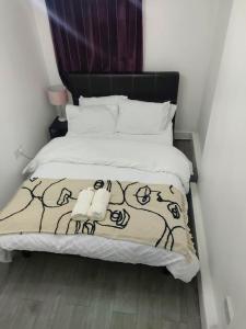 een slaapkamer met een bed met een zwart-witte deken bij Home Away Barking in Barking