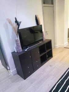 a flat screen tv sitting on top of a entertainment center at Home Away Barking in Barking