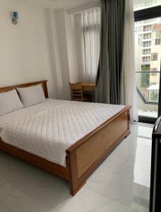 a bedroom with a bed and a large window at Hoang Hoa Tham Apartment in Nha Trang