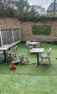 a group of tables and chairs in a yard at Home Away Barking in Barking