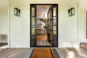 an open door on a house with a rug at 50 Acre Countryside Haven With Hiking Trails, Fossils, Pickleball Court, Basketball, Arcade, In-Ground Trampoline, Pool and Jacuzzi residence in Glen Rose
