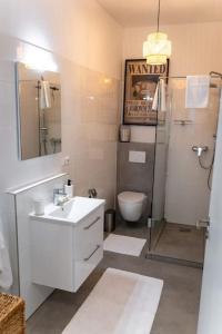 een badkamer met een wastafel, een toilet en een douche bij Moderne Wohnung im Herzen Offenbachs in Offenbach