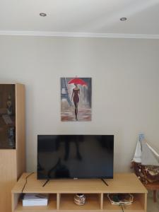 uma tela de TV com uma foto de uma mulher com um guarda-chuva em Just Constructed! em Gastoúni