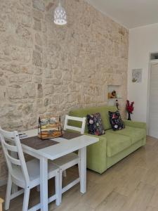 - un salon avec une table et un canapé vert dans l'établissement Casa Vacanze: Eureka, à Ostuni
