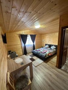 een kamer met een bed en een tafel in een hut bij La căbănute in Sibiu