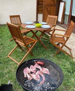 a grill with meat and two chairs and a table at Vall Fosca Apartment "Majue" in Torre de Capdella