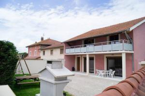 a pink house with a balcony and a picnic table at AU DOMAINE DE CHASSE in Beauvoir-de-Marc