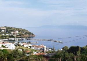a town on a hill with a body of water at Calm Rooms in Agioi Apostoli