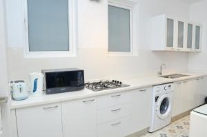 VeremにあるSanta Tera Homely 1&2bhk Apartments With Common Pool & Kitchen & Security & Wifi, Near to Candolimのシンクと電子レンジを備えた白いキッチン