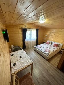 a bedroom with a bed and a table in a room at La căbănute in Sibiu