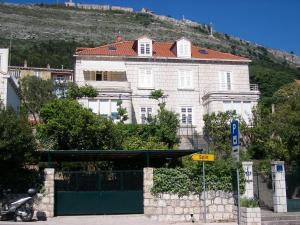 un gran edificio blanco con techo rojo en una colina en Villa Benic, en Dubrovnik