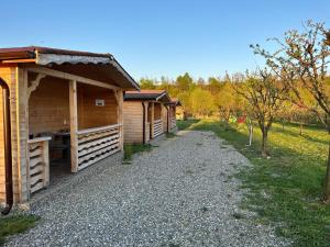 una fila de cabañas de madera en un camino de grava en La căbănute, en Sibiu