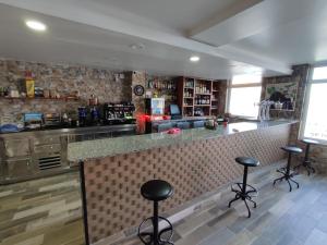 een keuken met een bar met krukken bij Hospedaje FranXu in Fene