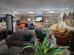 eine Lobby mit Sofas und Stühlen sowie einem TV in der Unterkunft Hospedaje FranXu in Fene