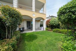 a house with a green yard in front of it at Appartamento Amaryllis, incantevole con piscina in Salò