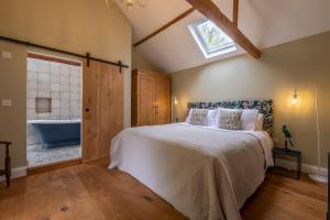 a bedroom with a bed and a bathroom with a tub at The Firs Luxury Lodges and Glamping Tents in Cratfield