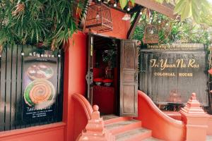 a restaurant with red walls and stairs with a sign at Tri Yaan Na Ros Colonial House in Chiang Mai