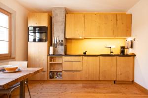 a kitchen with wooden cabinets and a table at Das haus in spay an der Mosel mit Sauna in Zell an der Mosel