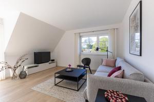 a living room with a couch and a tv at Lieblingsplatz in Born