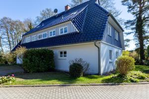 a white house with a blue roof at Lieblingsplatz in Born
