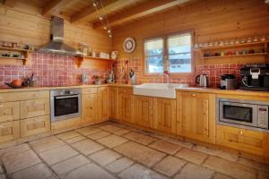 a kitchen with wooden cabinets and a sink at Chalet Beauvoir 12 - OVO Network in Saint-Jean-de-Sixt